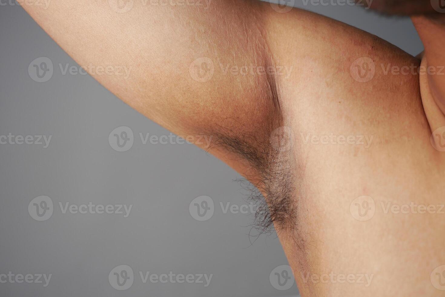 young man raised his hand up and showing his unshaven armpit photo