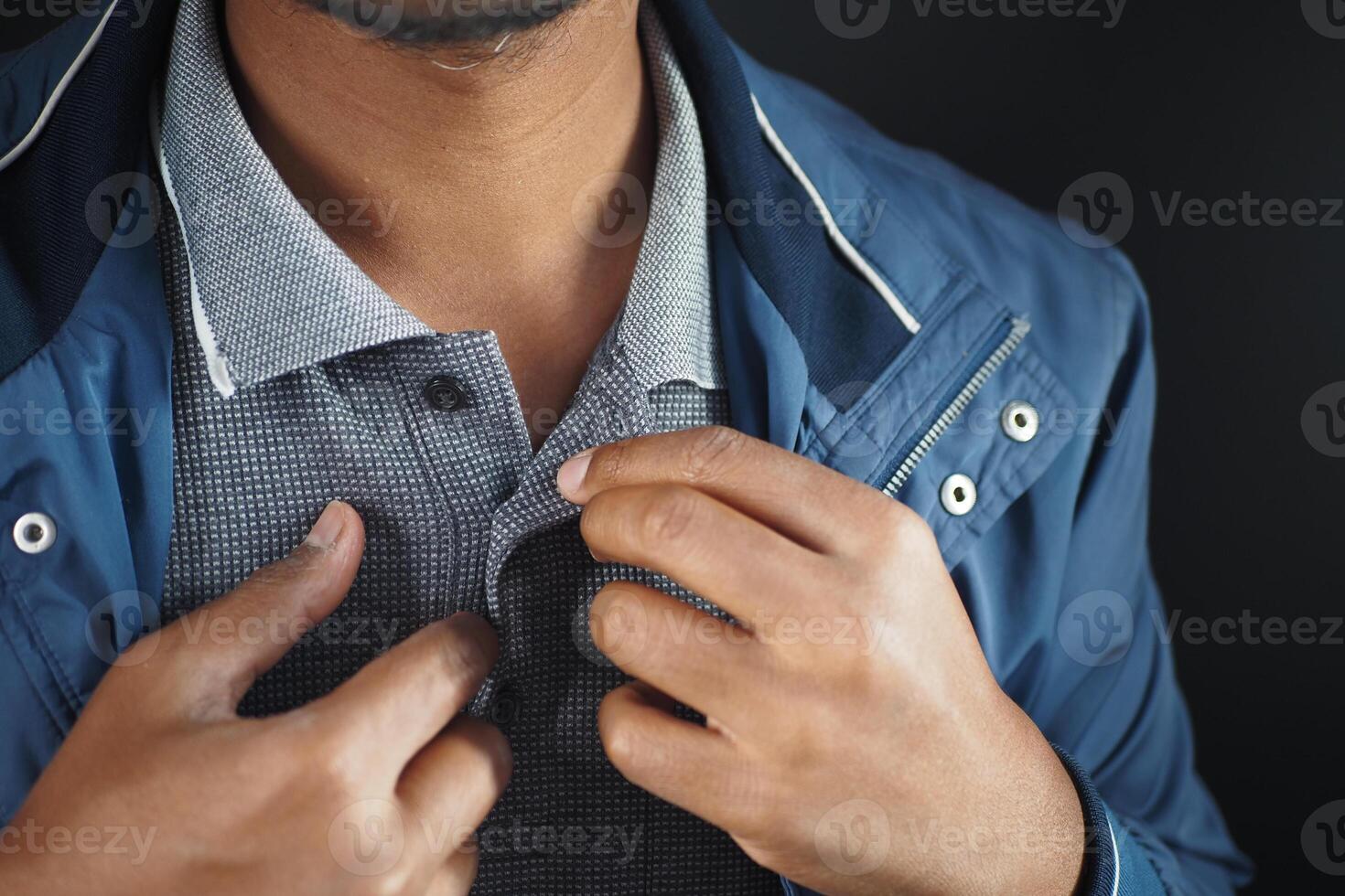 Man buttoning his shirt close up photo