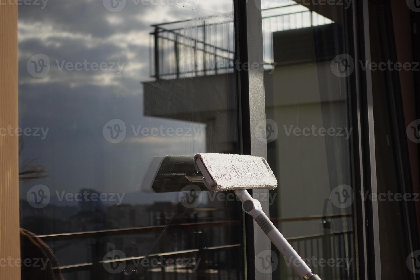 Rubber squeegee cleans a soaped window. photo