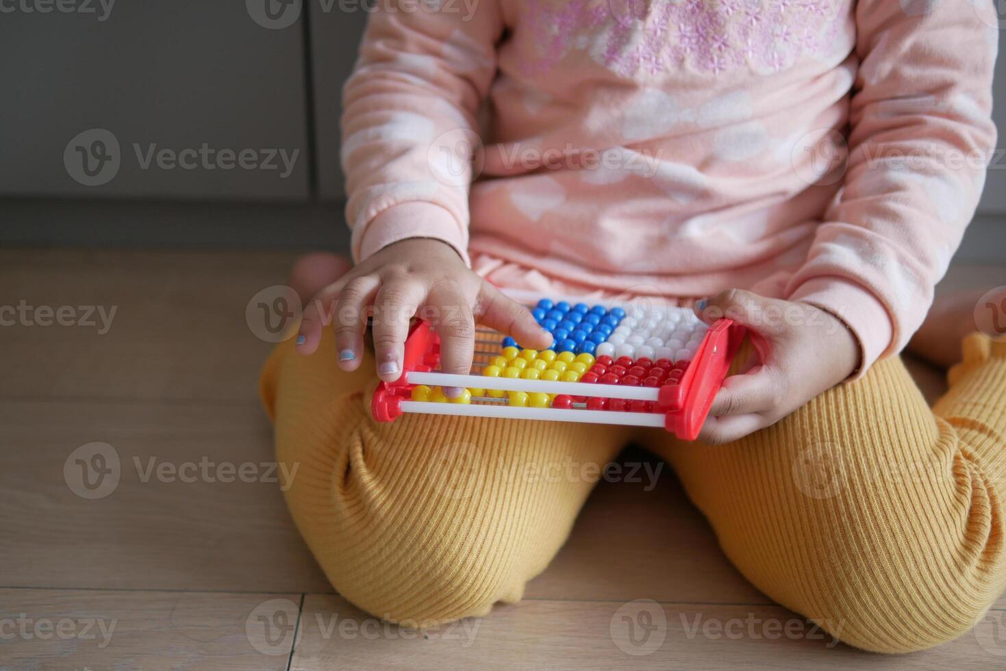 toddler playing with counting math learning toy . photo