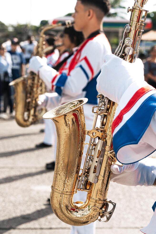 Closeup of saxophonists playing a saxophone in a parade. photo