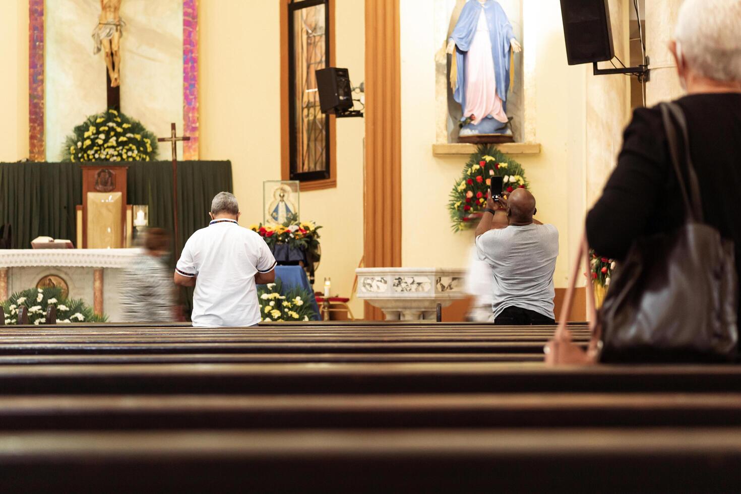 Unrecognizable people inside the San Isidro Cathedral praying. photo