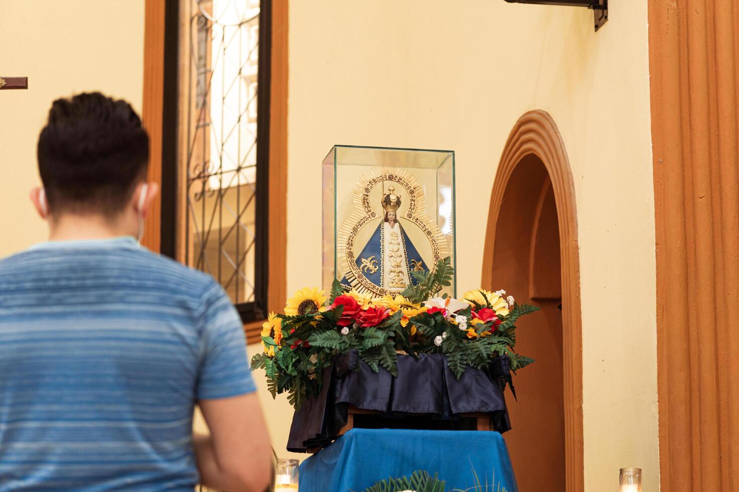 Unknown people praying front of the statue of Our Lady of Suyapa in the San Isidro Cathedral in La Ceiba, Honduras. photo