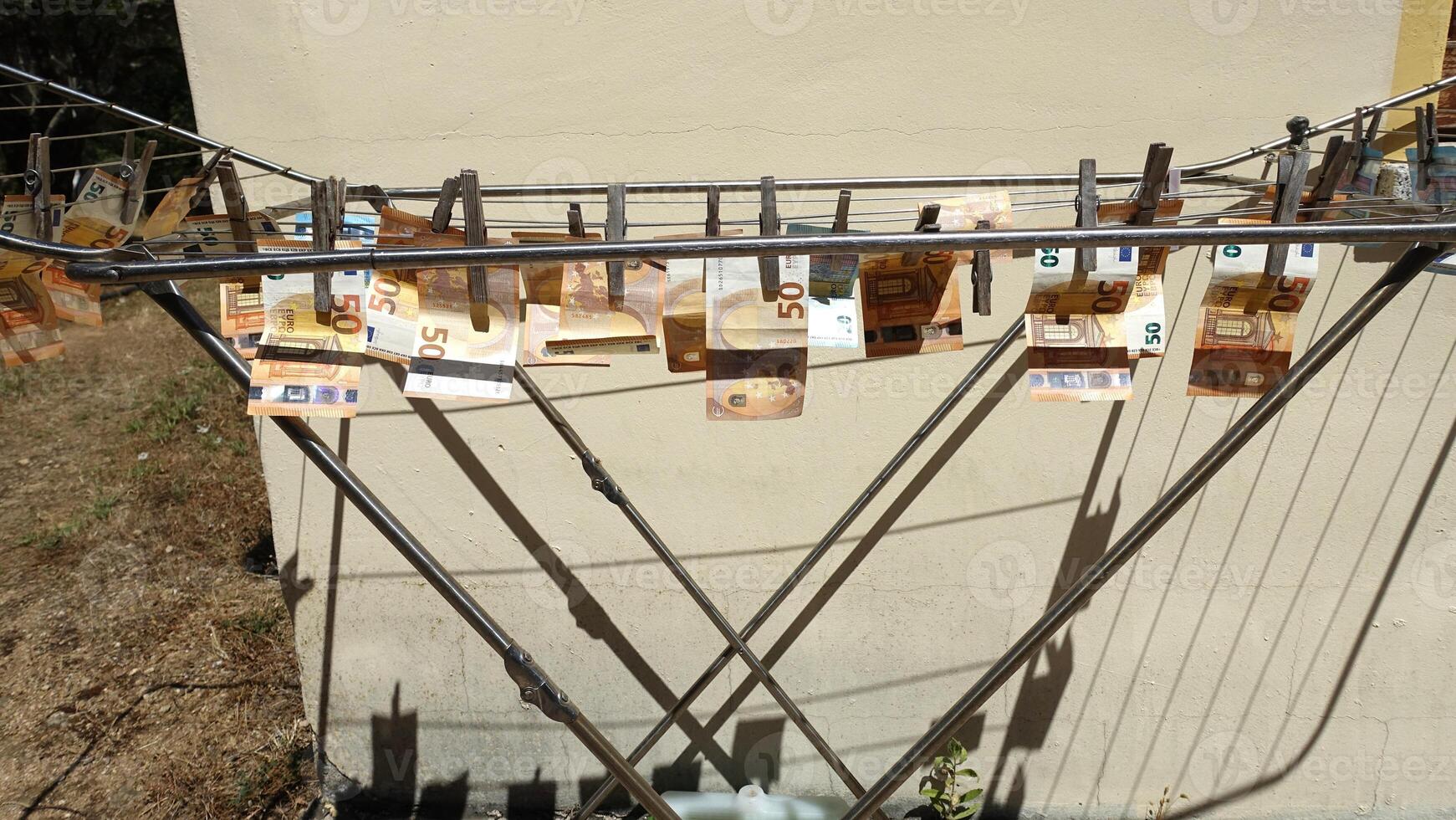 50 and 20 euro banknotes hung out to dry on a drying rack photo