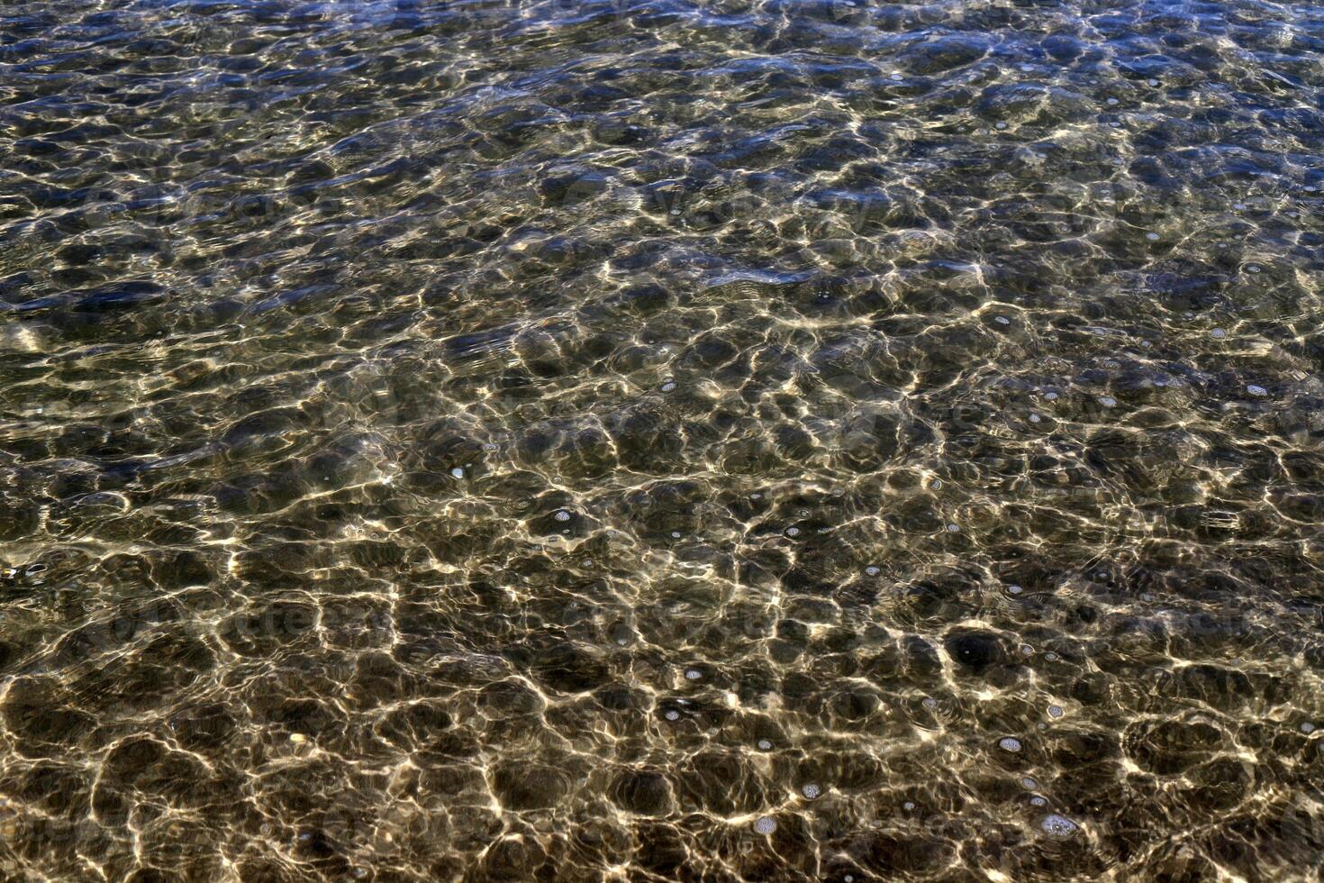 The color of water in the Mediterranean Sea in shallow water. Natural abstract background. photo