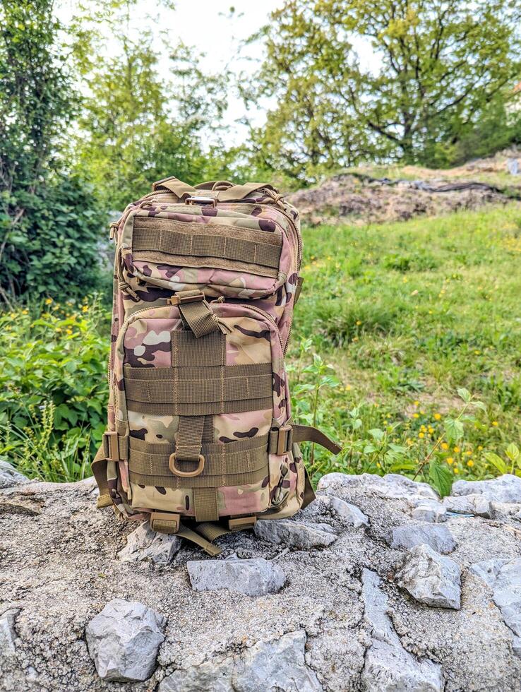 army military backpack, camo bag, hiking gear and accessories, nature background photo