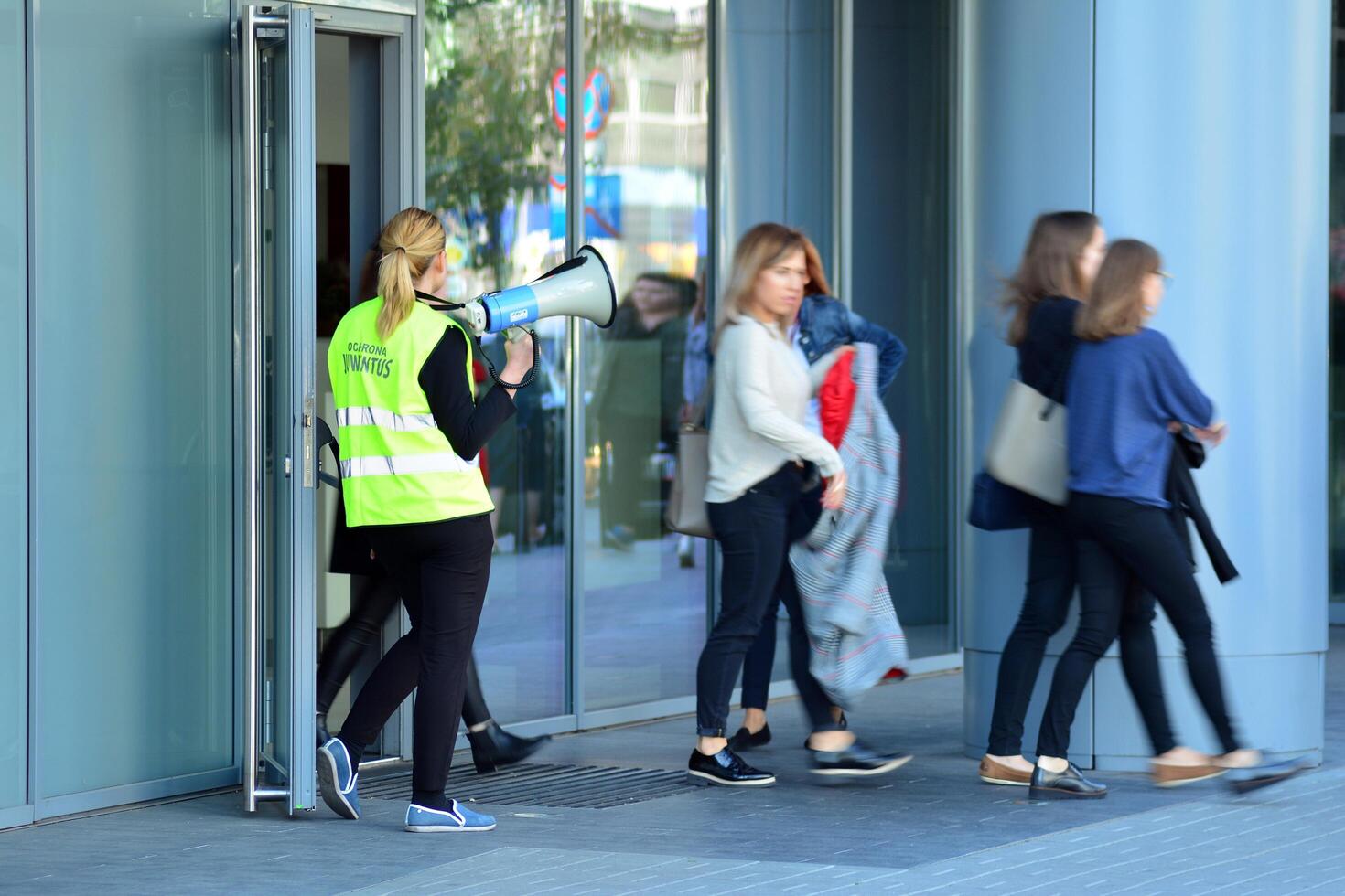 Warsaw, Poland. 15 October 2018. Evacuation of an office building. People exit the building on exit door. photo