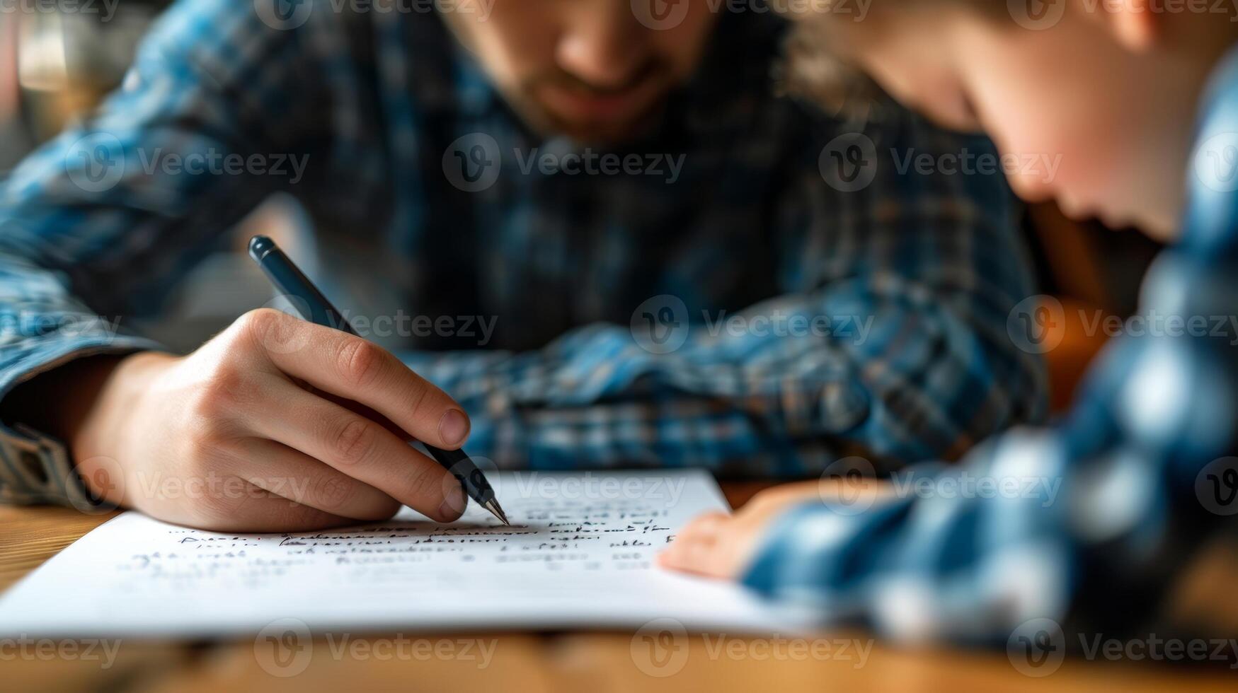 Father and son writing together, bonding over shared activity and enjoying quality time. Concept of family, education, and childhood development. photo