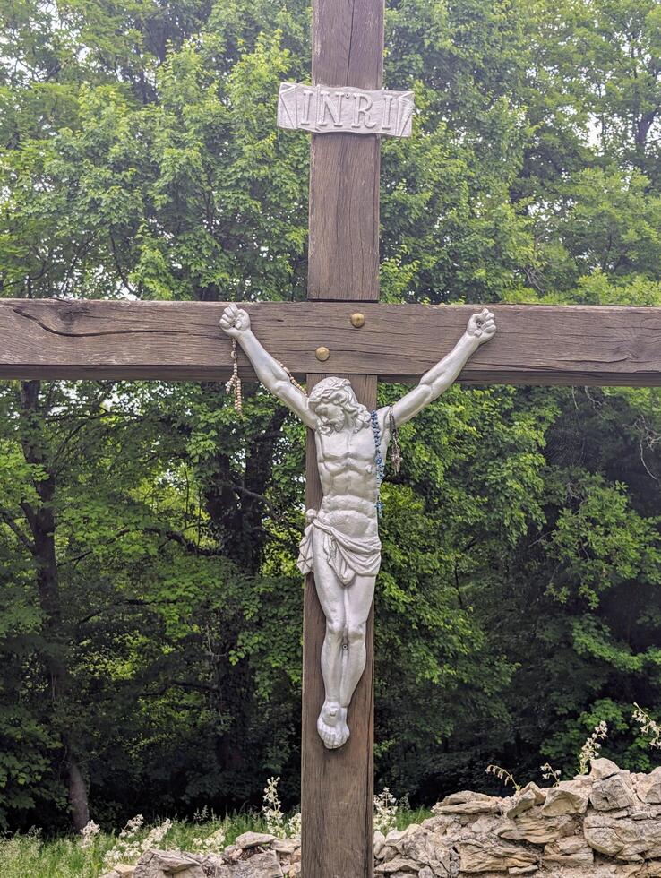 Jesus on the wooden cross in the forest, religion and Christianity background photo