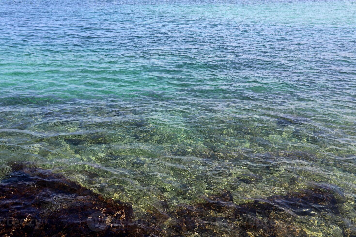 The color of water in the Mediterranean Sea in shallow water. Natural abstract background. photo