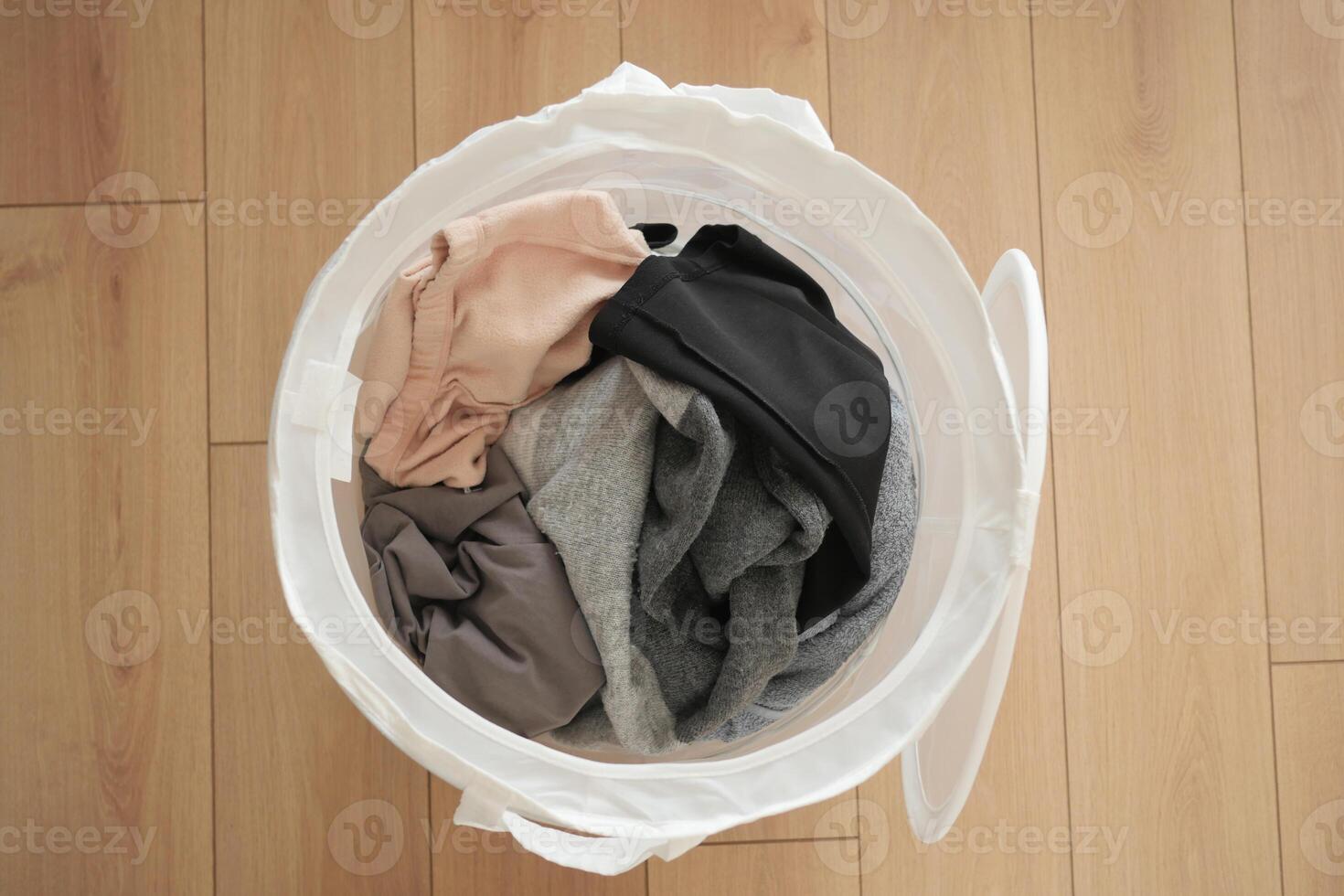 Old clothes thrown into the trash can. Disposal and recycling of clothes. photo
