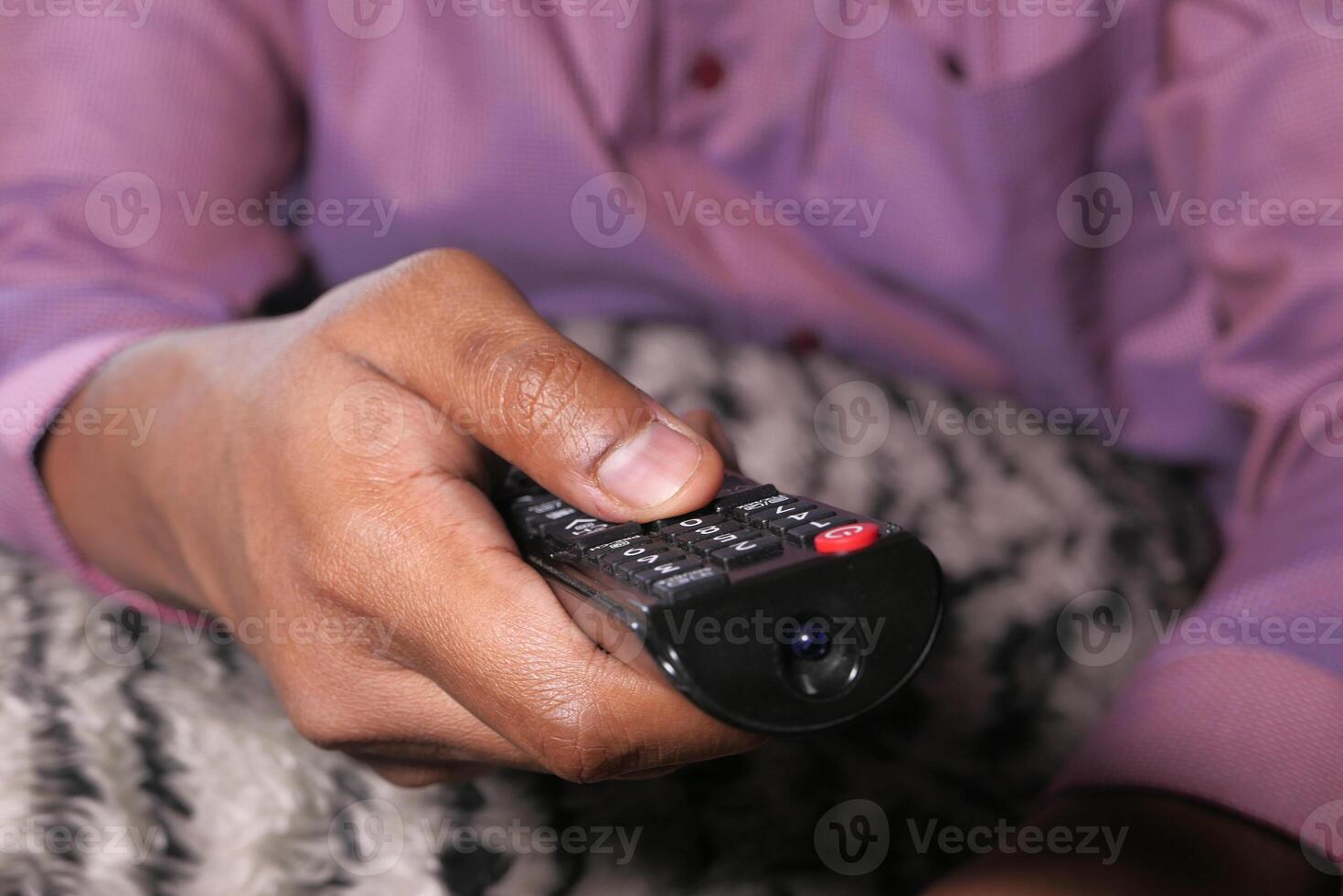 close up of man hand holding tv remote. photo