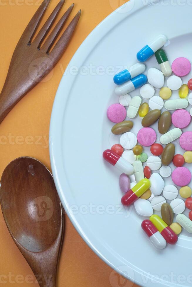 Top view of colorful medicine pills and capsules in plate. photo