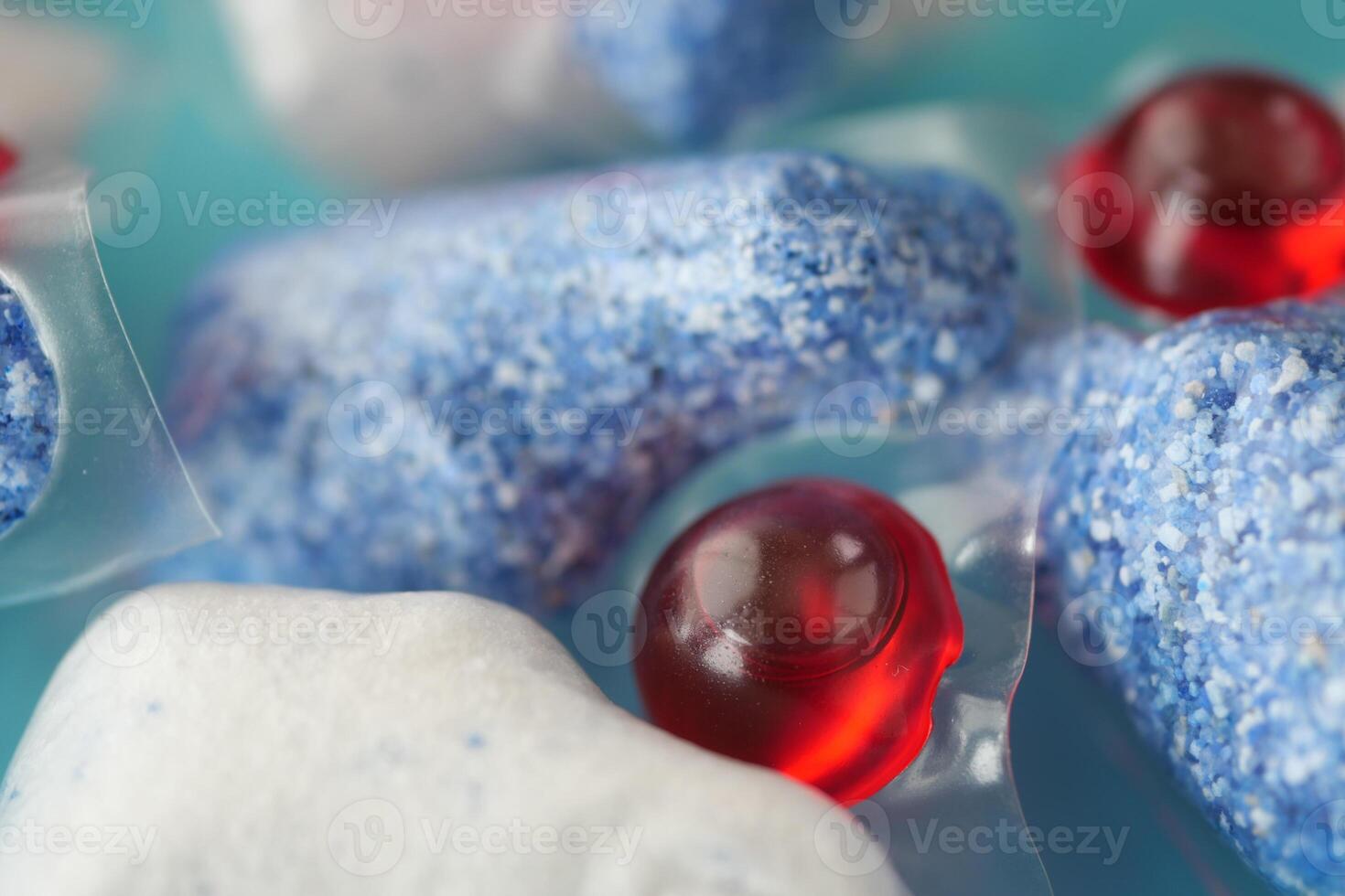 A stack of dishwasher tablets and a bottle of detergent on a blue background photo