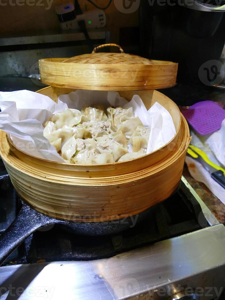 Steaming dim sum shumai in a bamboo basket photo