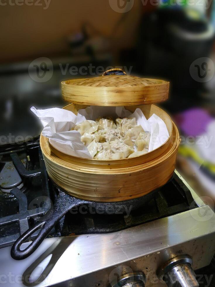 Steaming dim sum shumai in a bamboo basket photo