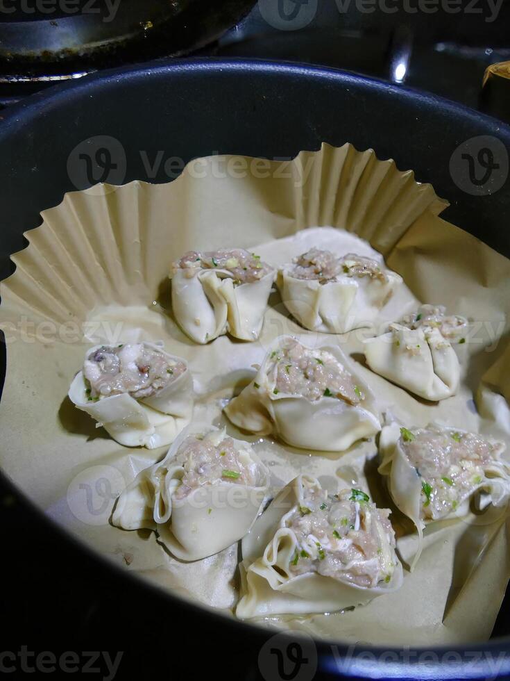 Steaming dim sum shumai in a bamboo basket photo