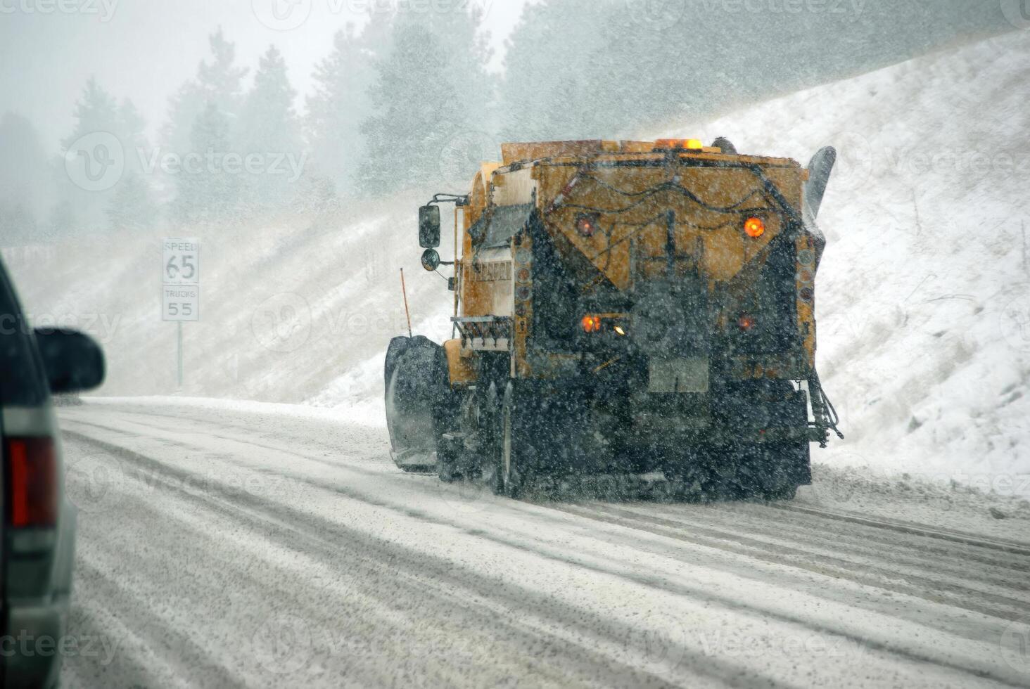 Snowplow truck on icy road photo