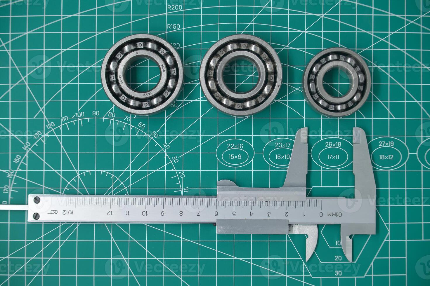 Measure caliper and roller bearings on cutting mat photo