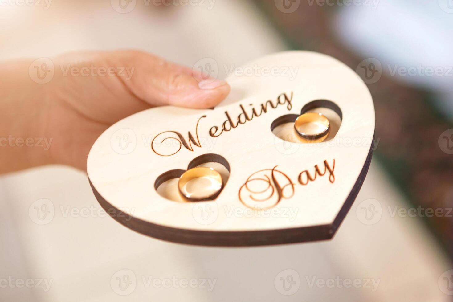 newlyweds wedding rings on a wooden heart-shaped stand in the church photo