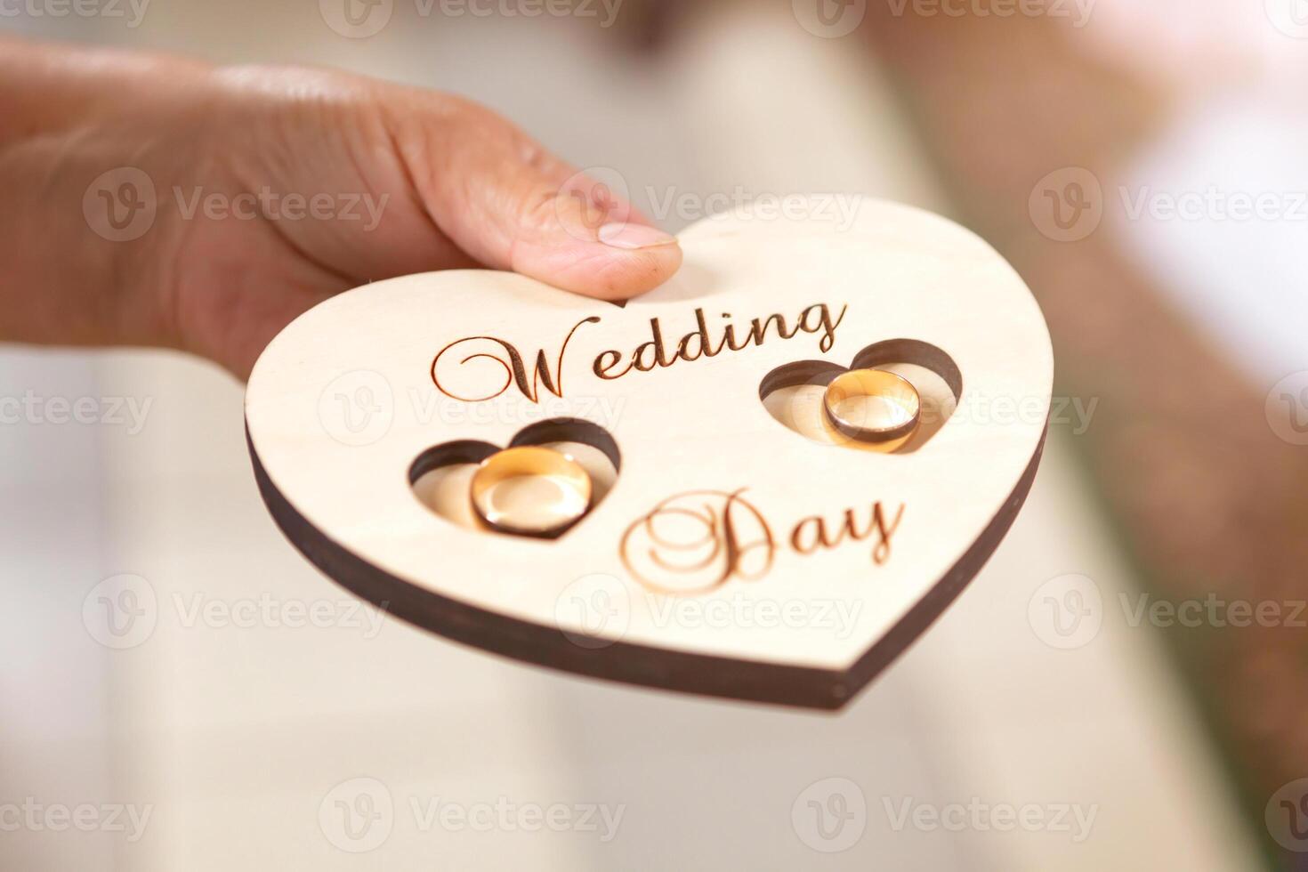 newlyweds wedding rings on a wooden heart-shaped stand in the church photo