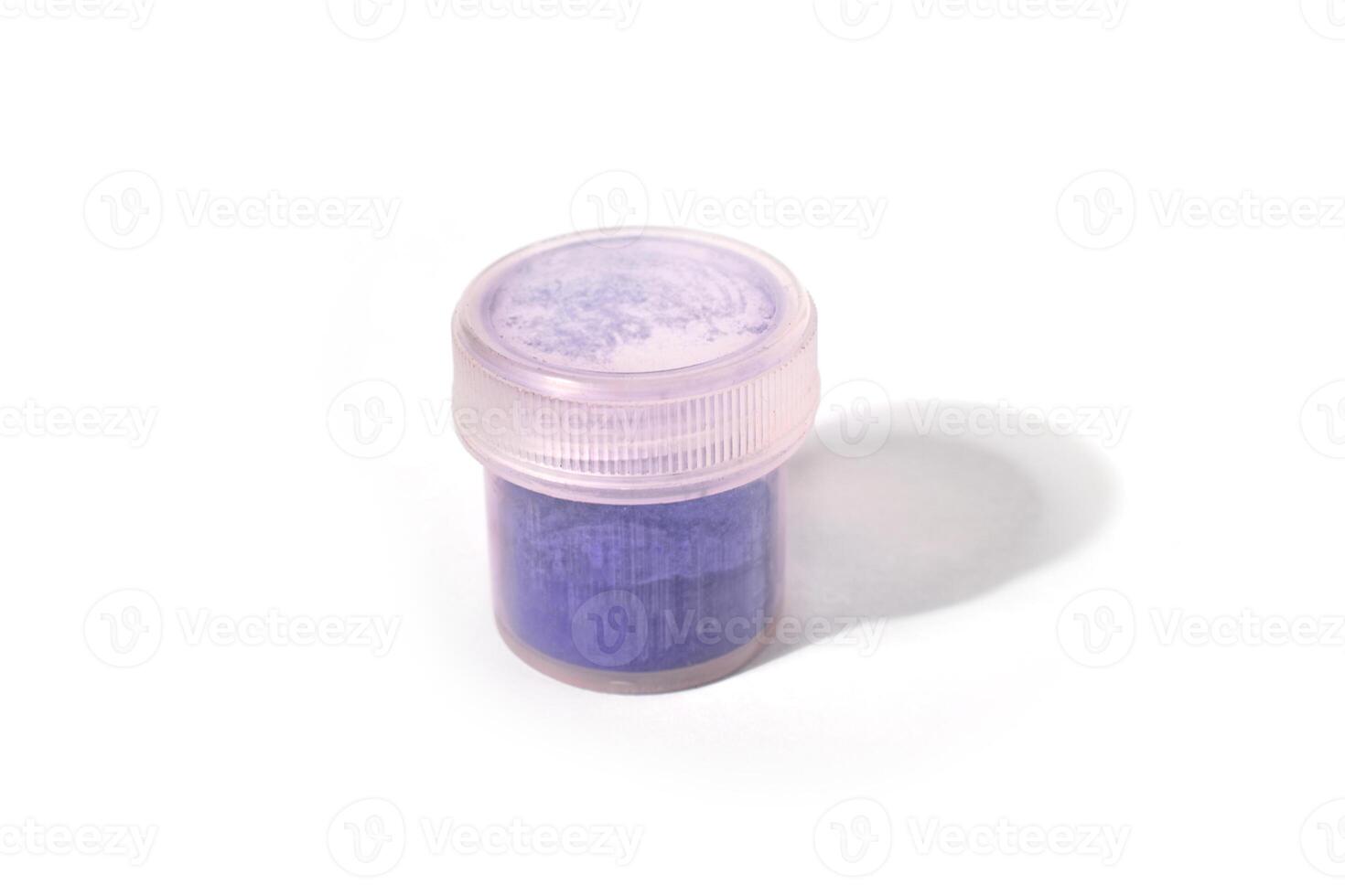 jar with dry natural purple pigment on a white background. macro photo