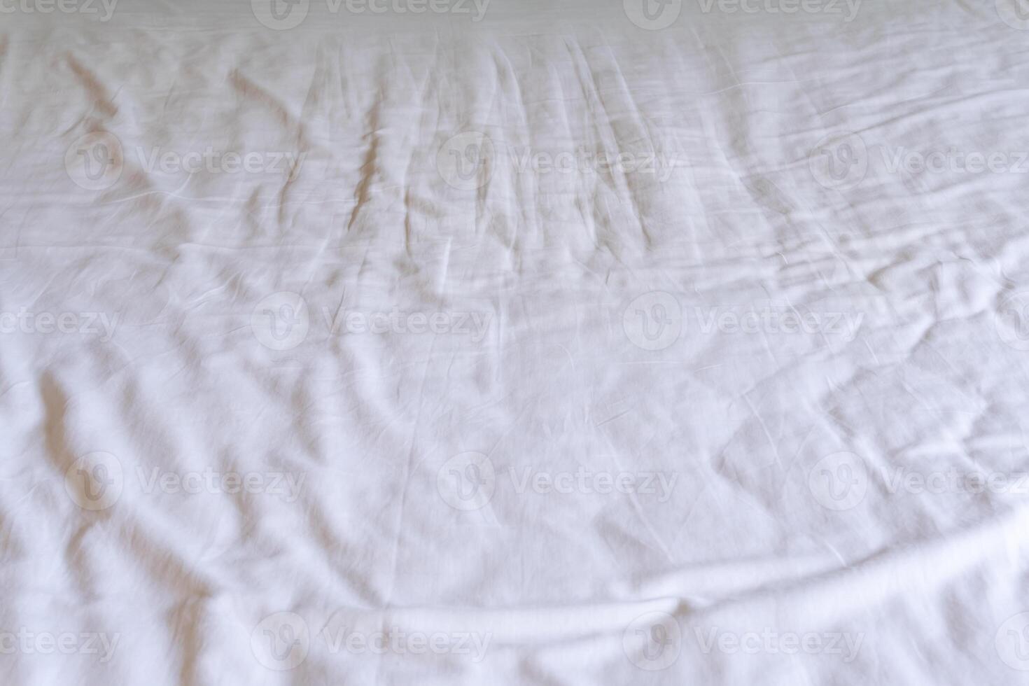 Crumpled or wrinkled white bedding sheet background texture taken with soft natural light used for clothing background texture photo