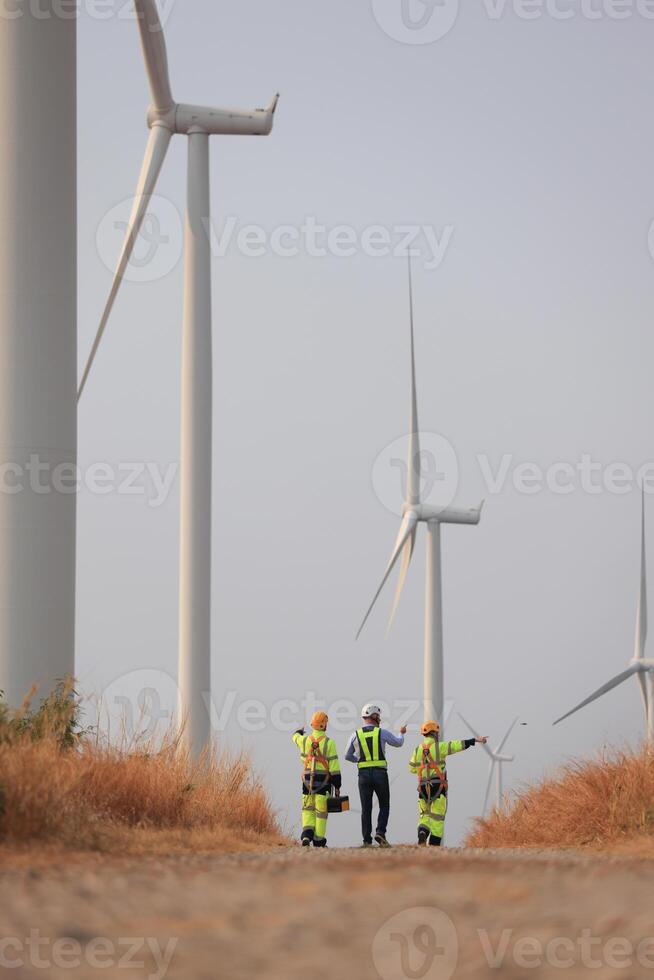 Specialist wind turbine Team of Engineers discussing Green Energy Production in Wind Turbines Farm photo
