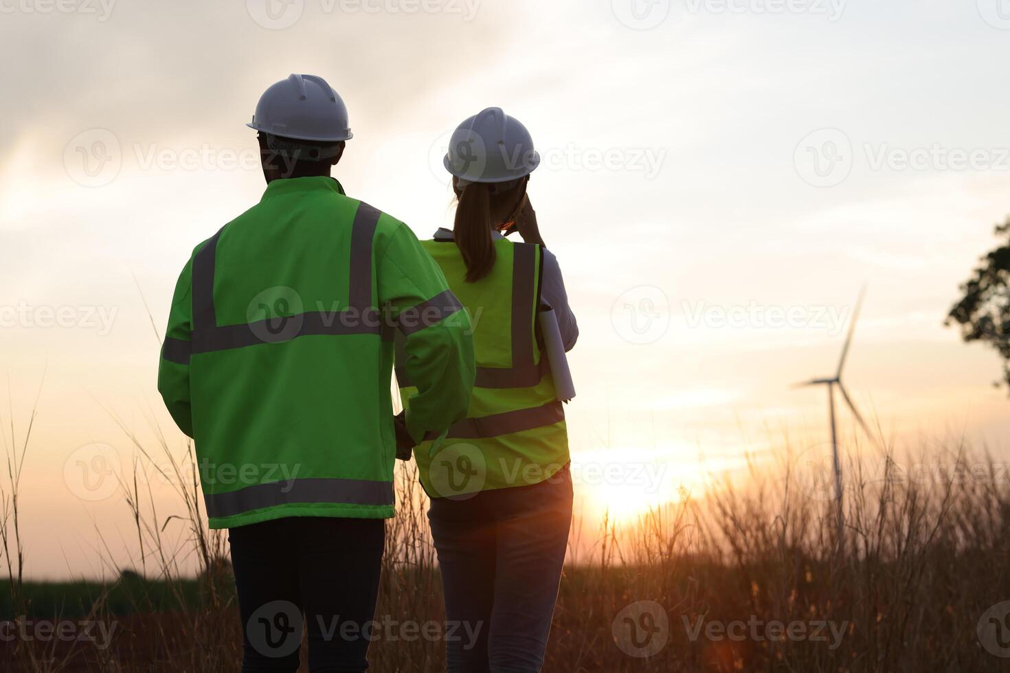 Silhouette a couple of electrical engineer working at windmill field. ecology energy renewable alternative green power environment factory concept photo