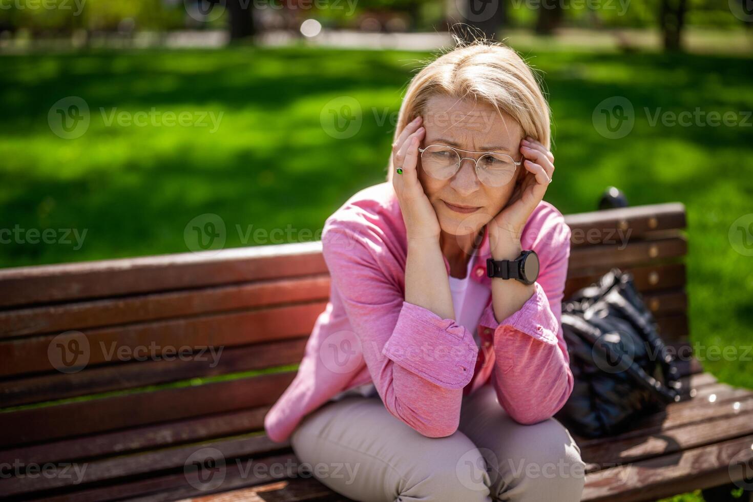 Portrait of mature woman in park. She is worried and depressed. photo