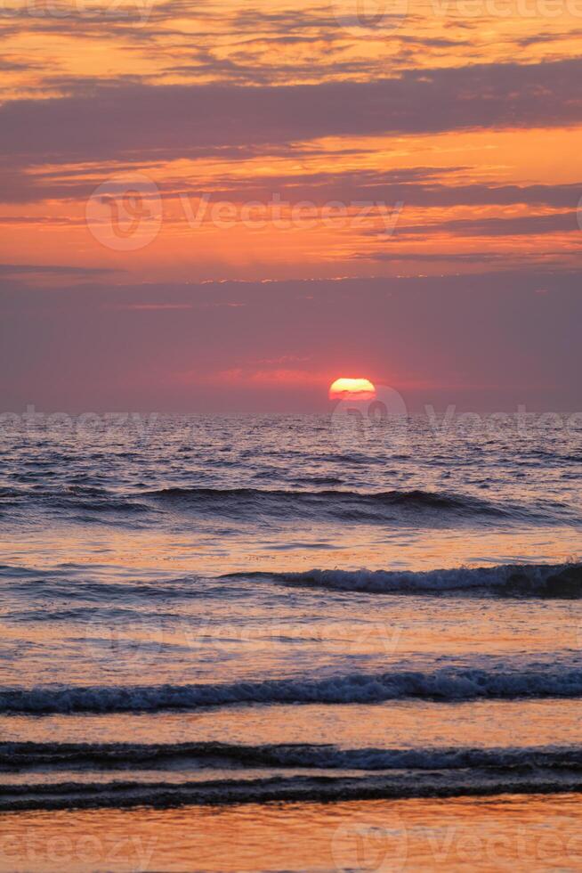 Ocean waves on sunset background photo