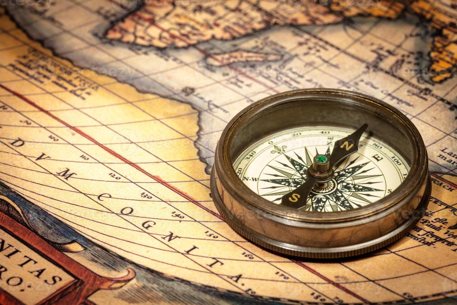 Old vintage compass on ancient map photo