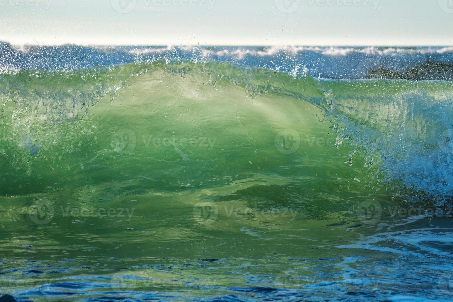 Breaking ocean wave on sunset photo
