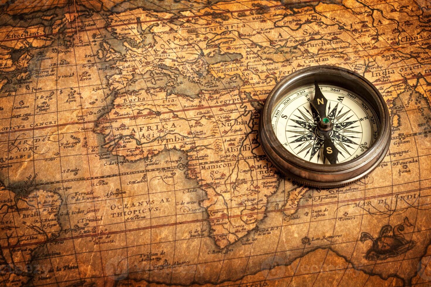 Old vintage compass on ancient map photo