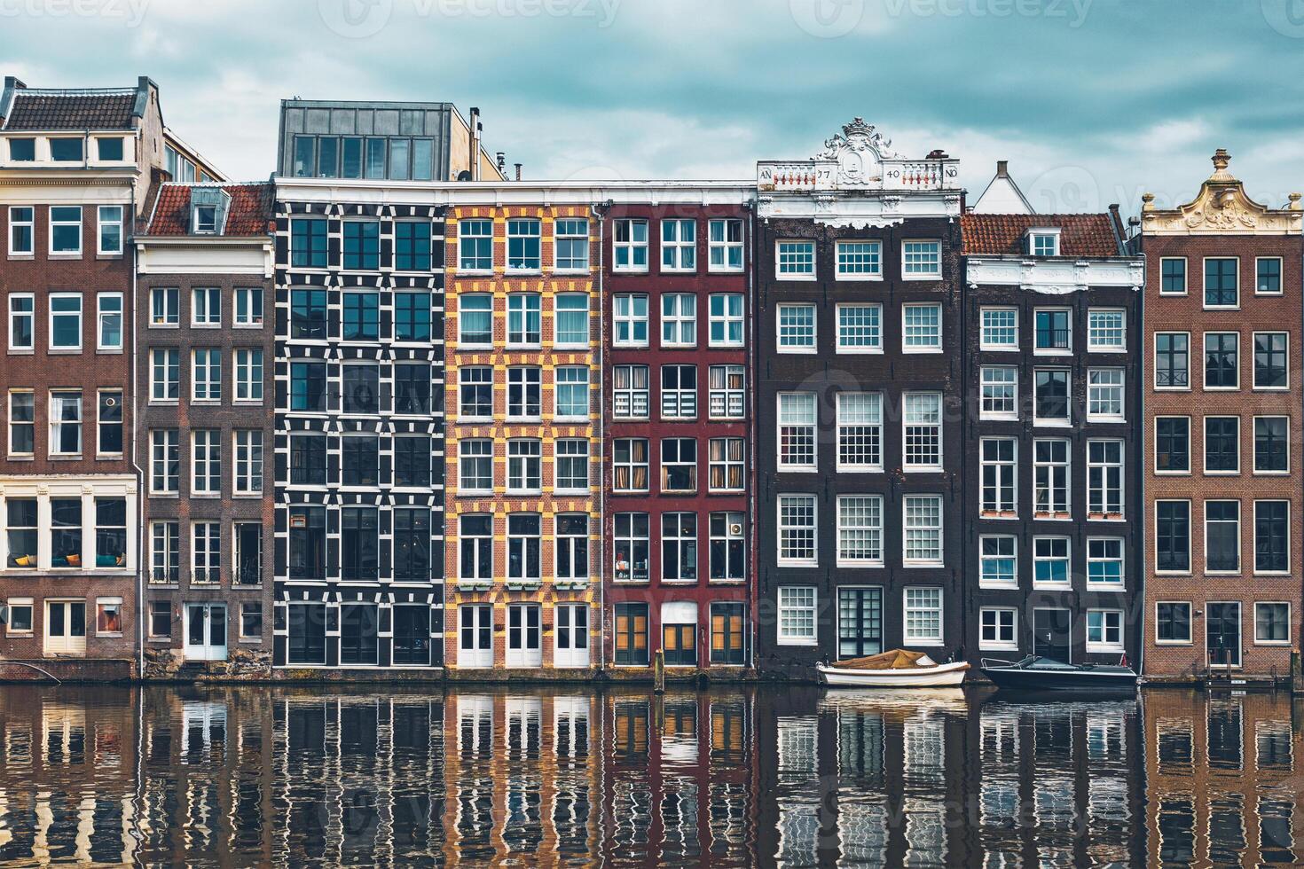 houses and boat on Amsterdam canal Damrak with reflection. Ams photo