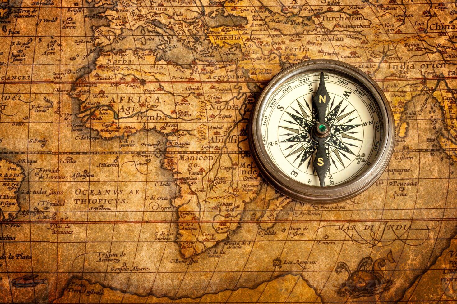 Old vintage compass on ancient map photo
