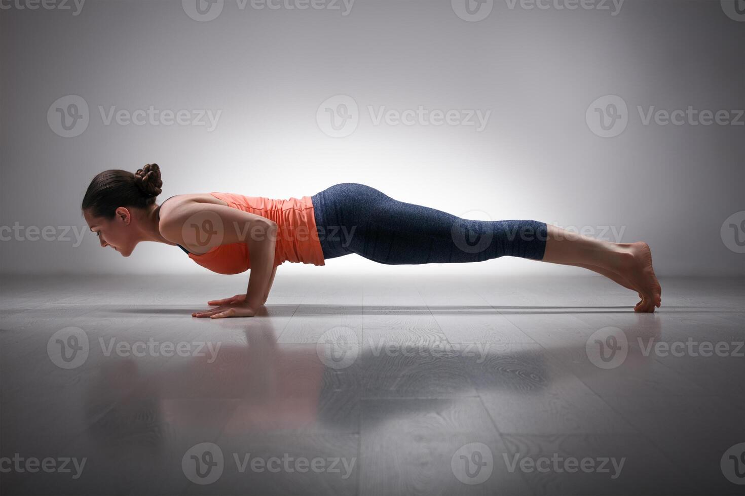 Woman practices yoga asana Chaturanga Dandasana photo