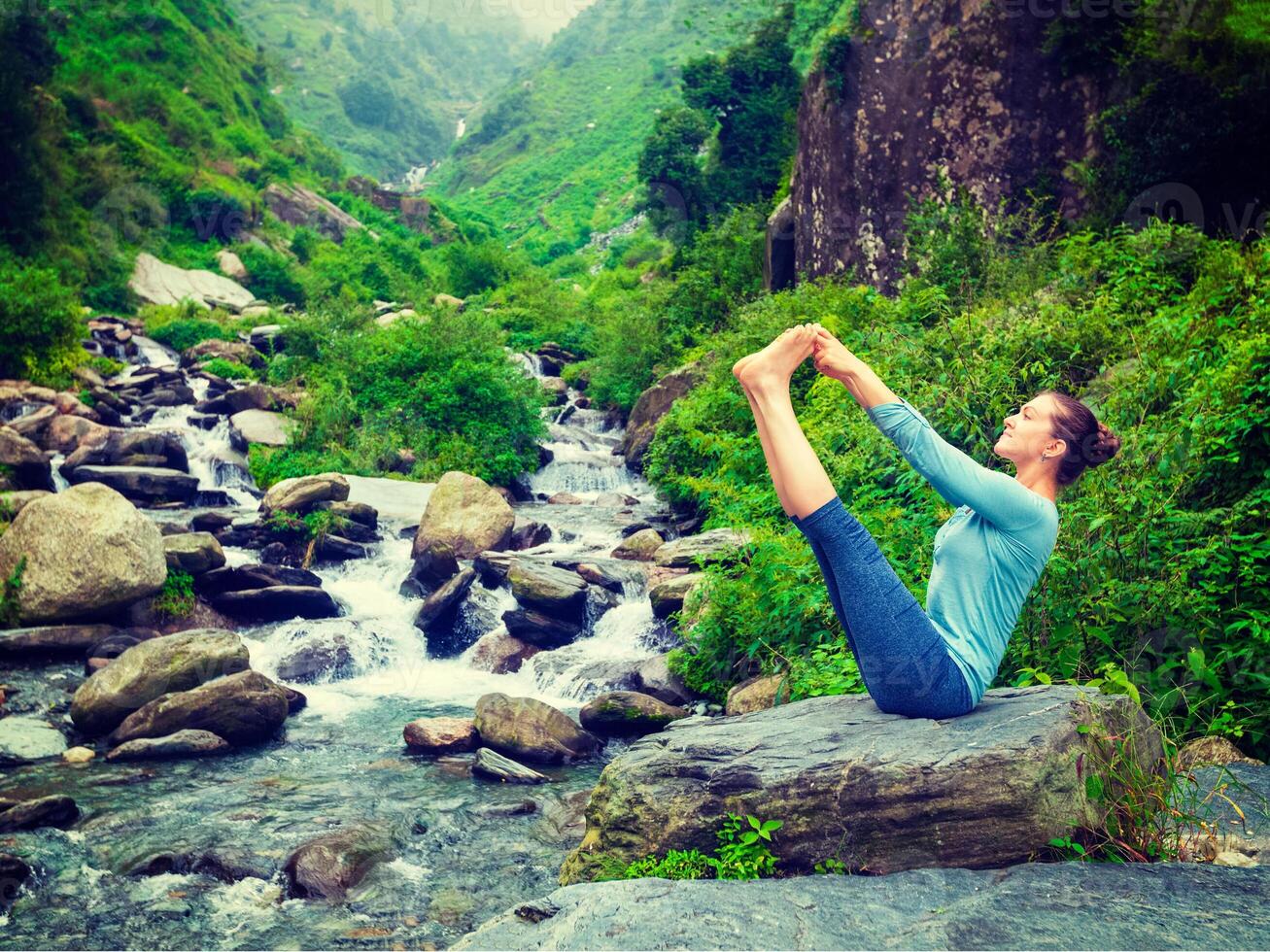 Woman doing Ashtanga Vinyasa Yoga asana outdoors photo