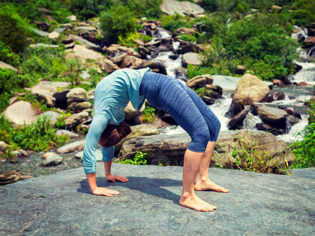 Woman doing Ashtanga Vinyasa Yoga asana Urdhva Dhanurasana - up photo
