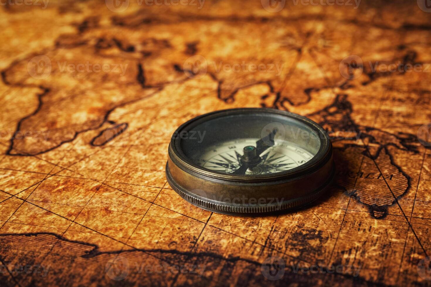 Old vintage compass on ancient map photo