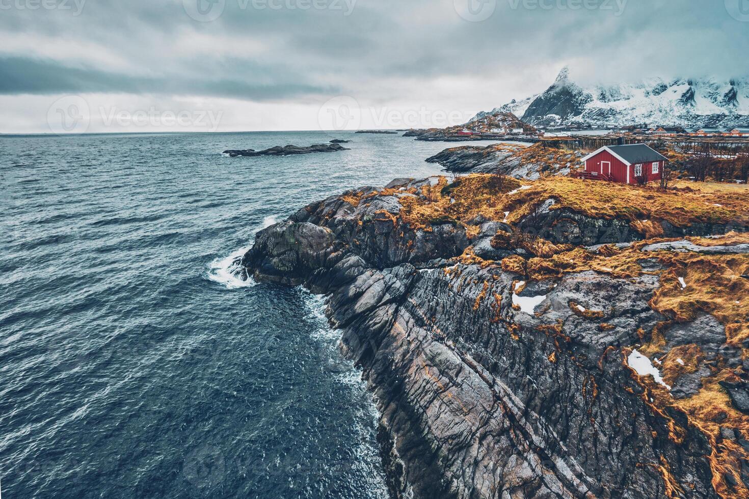 Clif with traditional red rorbu house on Lofoten Islands, Norway photo