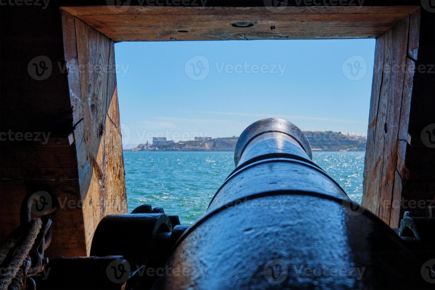 View out of a gunport in hull of the ship on the gun deck over the gun cannon muzzle in photo