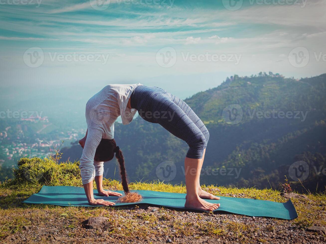 Woman doing Ashtanga Vinyasa Yoga asana Urdhva Dhanurasana photo