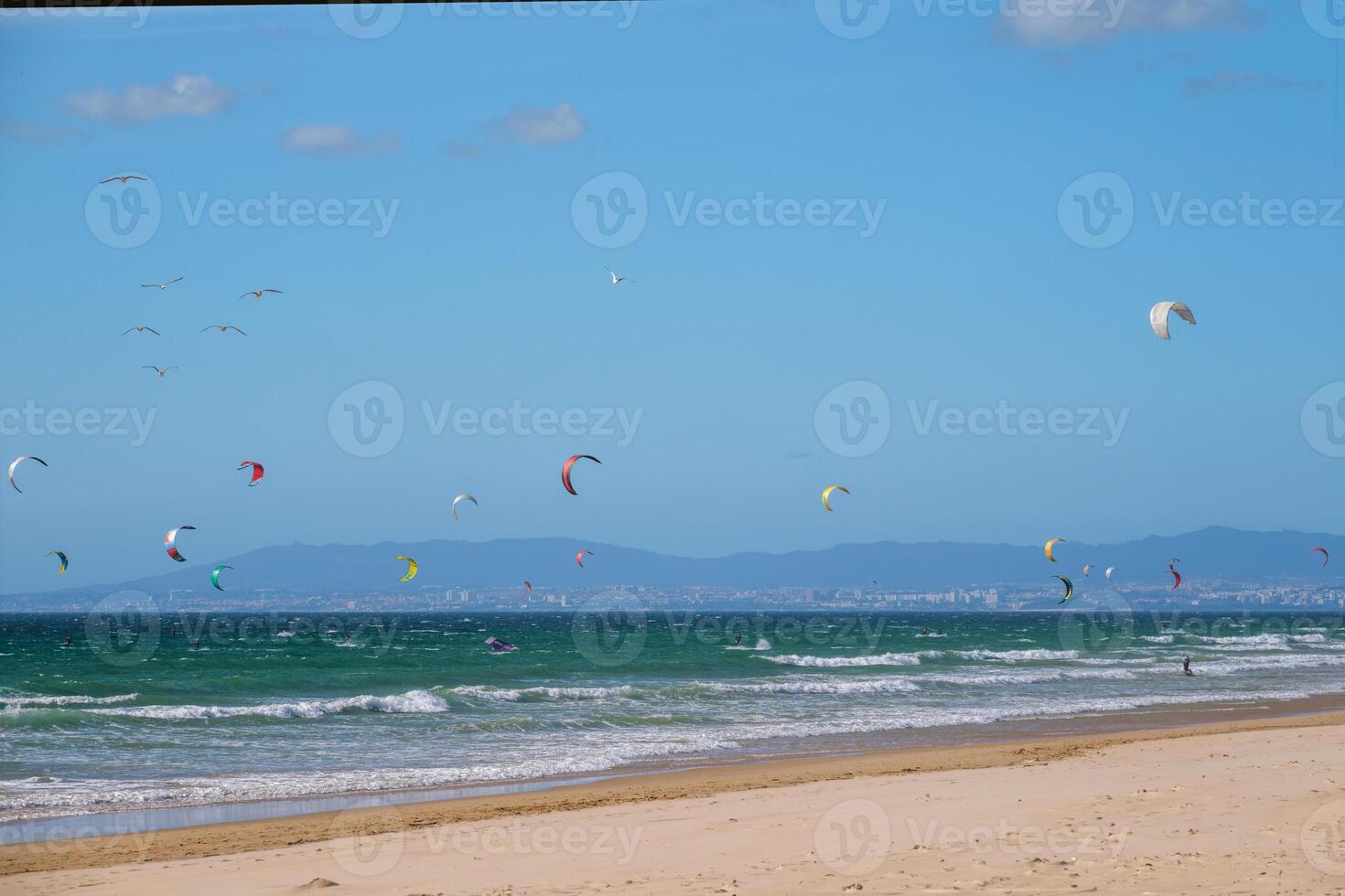 Kiteboarding kitesurfing kiteboarder kitesurfer kites on the ocean beach photo