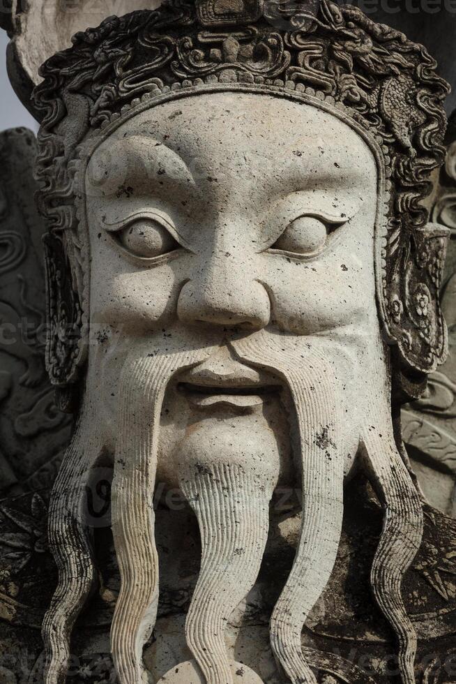 Wat Pho stone guardian face close up, Thailand photo