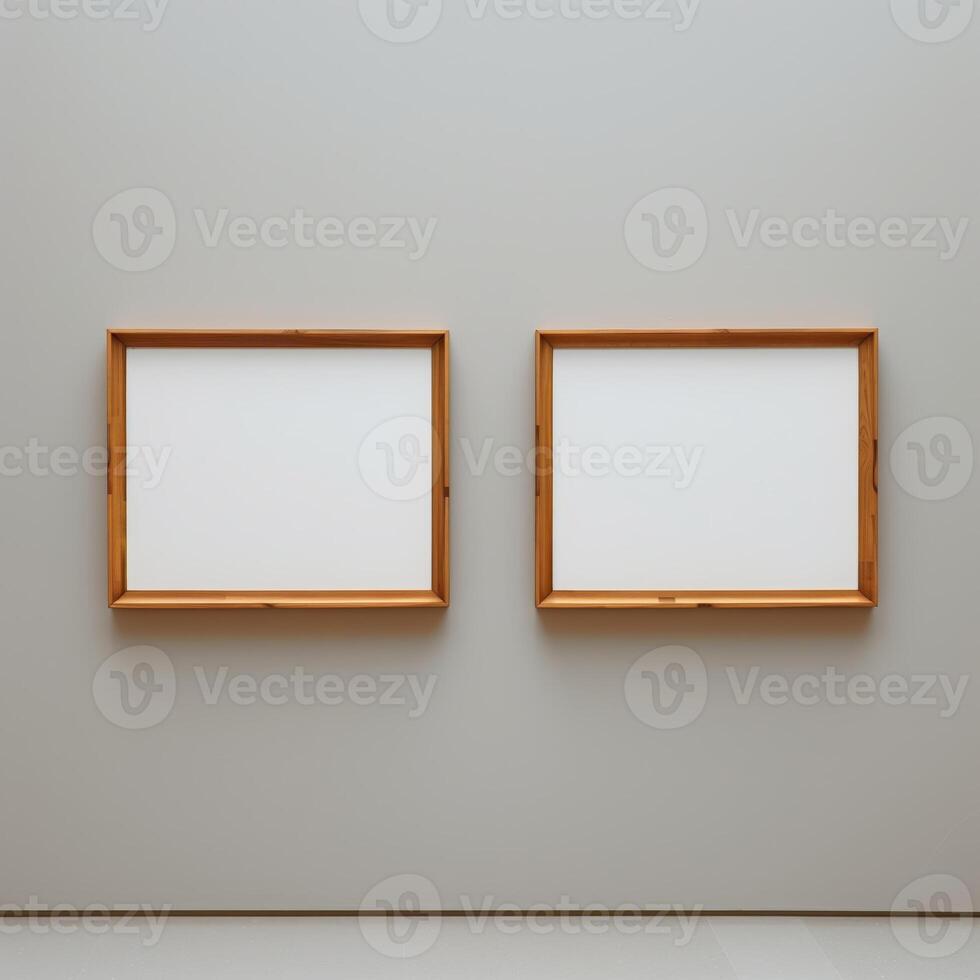 Two empty, wide, wooden frames on a light gray plain wall. photo