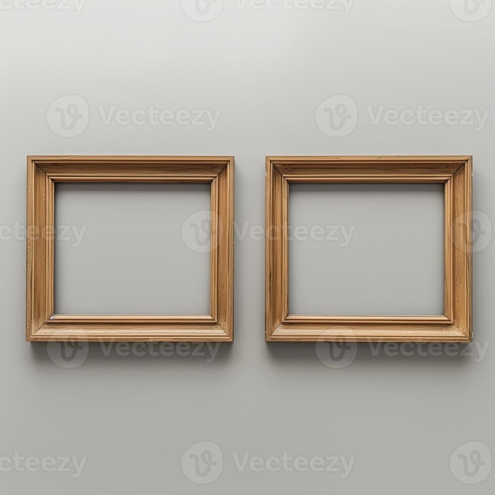 Two empty, wide, wooden frames on a light gray plain wall. photo