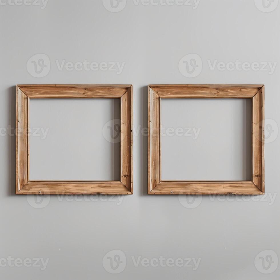Two empty, wide, wooden frames on a light gray plain wall. photo