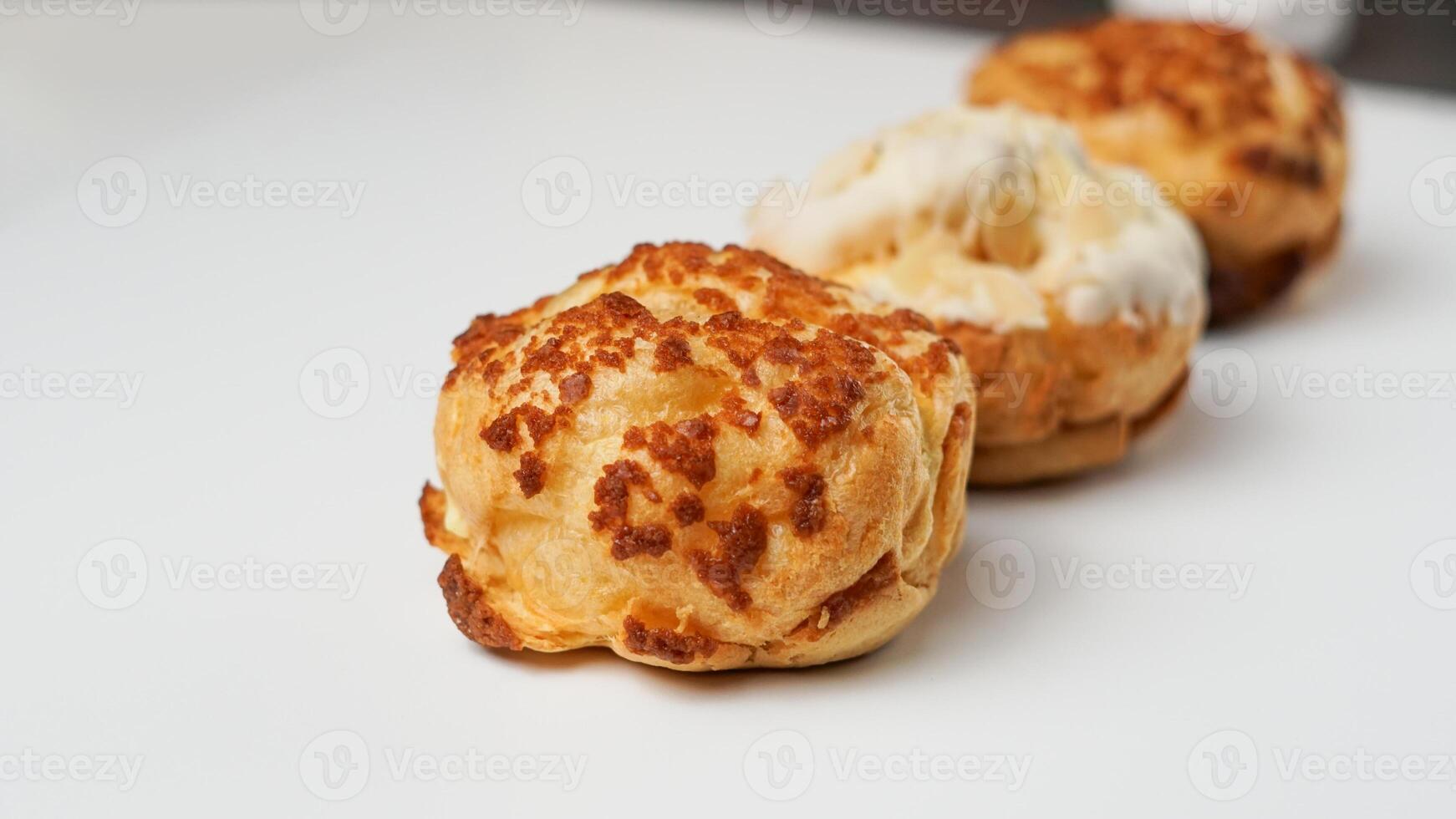 Freshly baked cream puffs or Vanilla eclairs isolated on white background photo