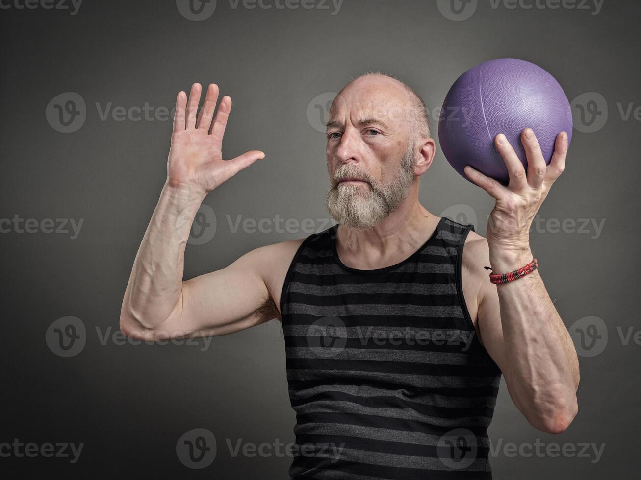 athletic senior man with a small medicine ball photo
